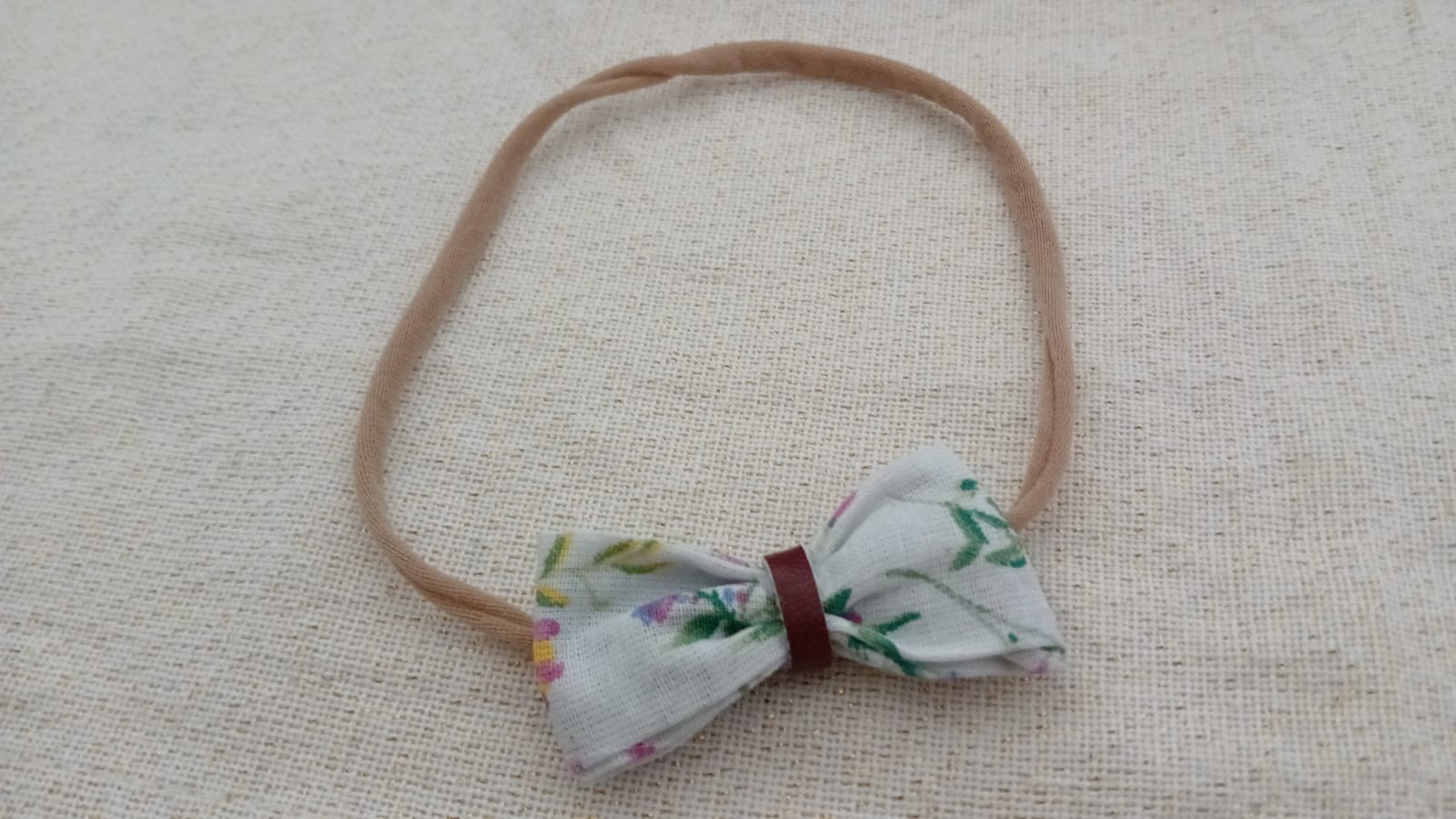 Meisjesbandana met groene strik en leren lint.
