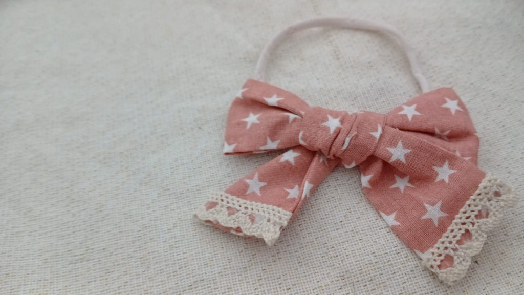 Hoofdband met oranje strik en witte sterrenprint