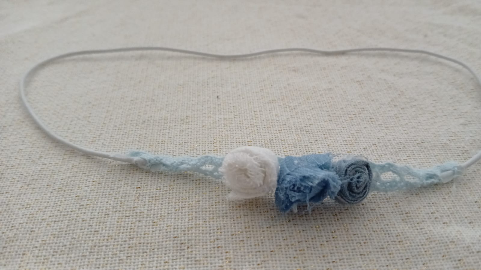 Haarband met drie rozen in blauwe en witte tinten.