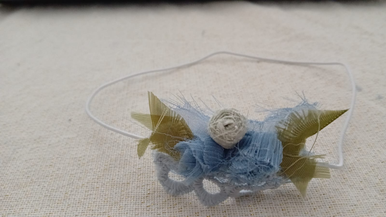Haarband met bloemen in verschillende tinten blauw en een witte roos.