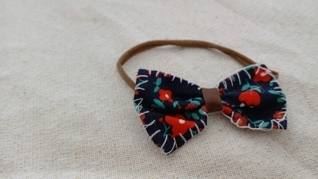 Hoofdband met zwarte strik en rode bloemen