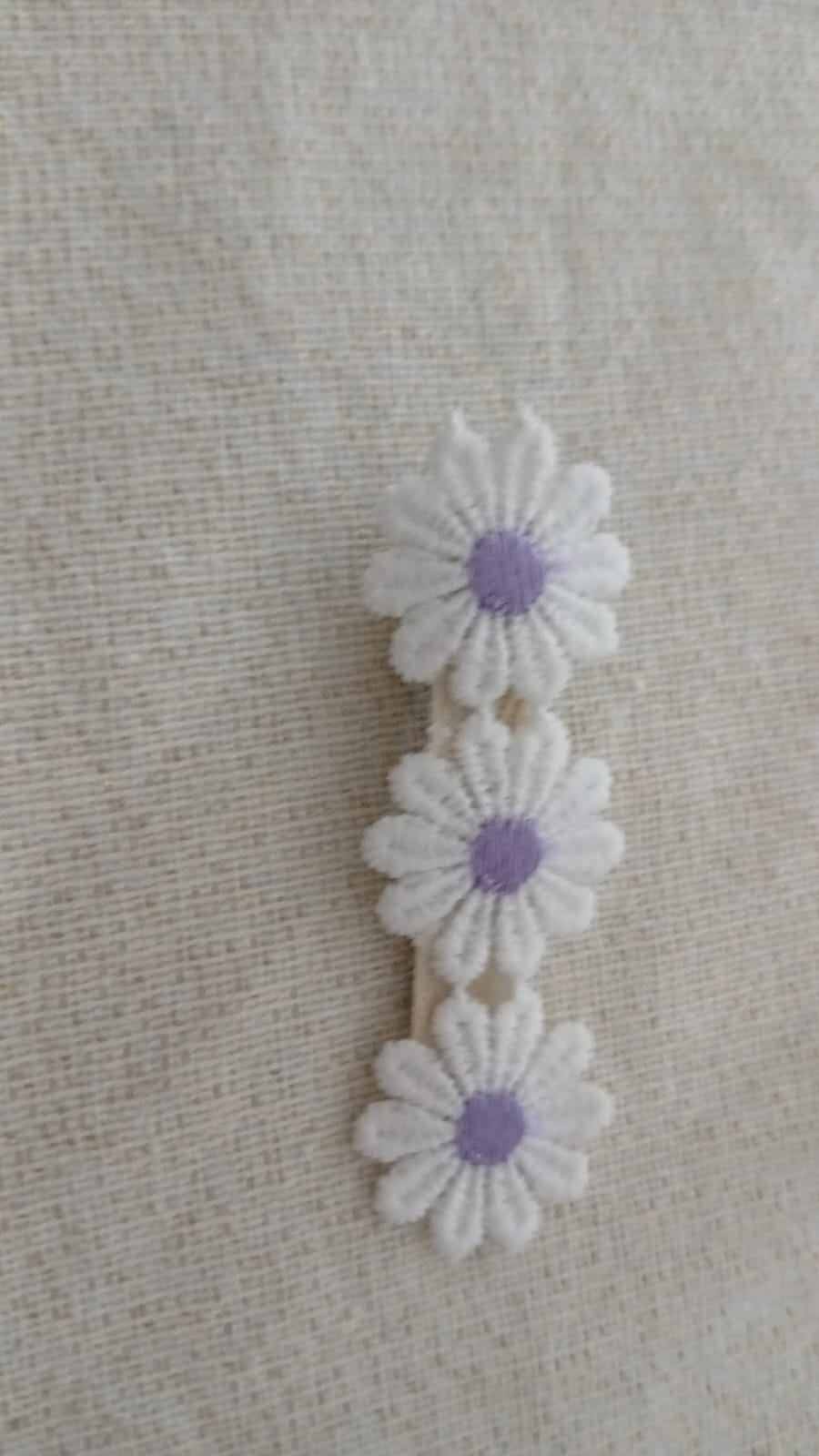 Violette Klammer mit drei lila Gänseblümchen
